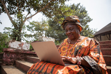 60 year old african woman uses her laptop, women and technology concept