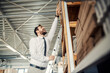 © Dusan Petkovic - A manager standing on ladders at printing shop and trying to reach box with materials.