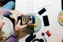 Directly Above Shot Of Young Woman Photographing Noodles While Studying In College Dorm