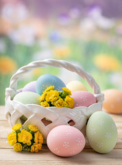 Wall Mural - Easter eggs and flowers in a basket and on a wooden table