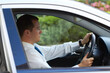 © Jose M/peopleimages.com - The daily commute. Profile of a businessman driving his car to work.