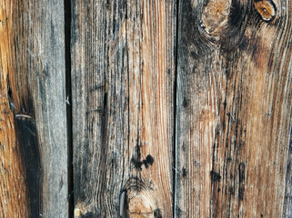 Old textured wooden brown-gray boards close-up background.