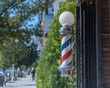 Los Angeles, CA, USA - February 25, 2022: Close up of a traditional Barber’s Pole in front of a barber shop in Los Angeles, CA.