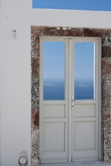  A typical door in Santorini with a breathtaking view of the Aegean Sea and the blue sky