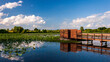 Wetlands landscape with a bird blind and cloudy sky reflected in a lake at the August A. Busch Memorial Conservation Area in St. Charles County Missouri