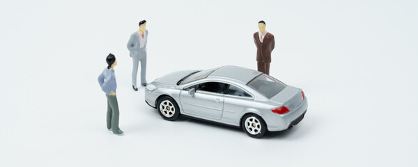 Poster - On a white surface is a car and miniature figures of people looking at the car.
