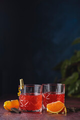 Wall Mural - Two glasses of chocolate red orange negroni, an italian cocktail, an aperitif, first mixed in Firenze, Italy, in 1919, alcoholic bitter cocktail served by ingredients on the dark claret table