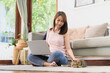 © interstid - Happy Asain woman playing with her cat during using laptop for in living room. Working at home concept