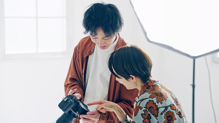Poster - カメラの液晶をモデルに見せるカメラマン