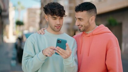 Wall Mural - Young hispanic couple smiling confident making selfie by the smartphone at street