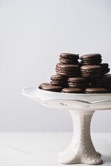 Wall Mural - A sweet chocolate macaron French,Chocolate macarons with chocolate ganache filling and mint leaves isolated. French meringue cookies macaron. Top view. Dark background. Copy space.