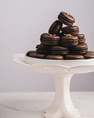 Wall Mural - A sweet chocolate macaron French,Chocolate macarons with chocolate ganache filling and mint leaves isolated. French meringue cookies macaron. Top view. Dark background. Copy space.