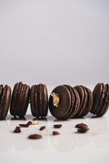 Wall Mural - A sweet chocolate macaron French,Chocolate macarons with chocolate ganache filling and mint leaves isolated. French meringue cookies macaron. Top view. Dark background. Copy space.