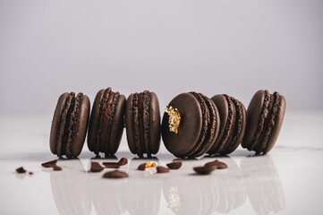 Wall Mural - A sweet chocolate macaron French,Chocolate macarons with chocolate ganache filling and mint leaves isolated. French meringue cookies macaron. Top view. Dark background. Copy space.