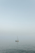 Lonely Sailboat Out On The Ocean Off The Mediterranean Sea In Sitges, Spain.