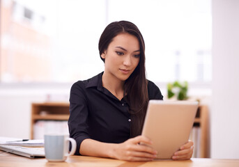 Poster - Living in a corporate world. Shot of a young businesswoman in her office.