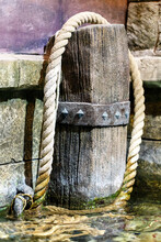 Mooring Rope Slung Over A Wooden Bollard