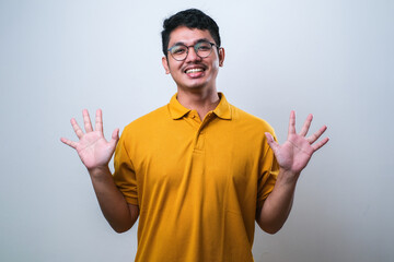 Wall Mural - Asian young man showing and pointing up with fingers number ten