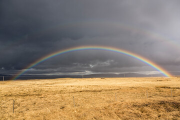 Scenery with dark clouds and rainbow over the raw coast of Snaefellsnes peninsula, Iceland