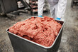 Close up of a ground beef meat in container at factory.