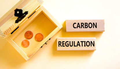 Wall Mural - Carbon regulation symbol. Concept words Carbon regulation on wooden blocks on a beautiful white table white background. Wooden chest with coins. Business and carbon regulation concept, copy space.