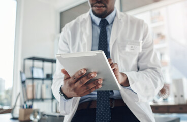 Poster - Now I can find information at the tap of a screen. Shot of an unrecognizable doctor using a digital tablet in an office.
