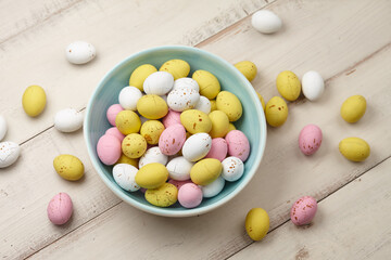 Wall Mural - Colorful glazed chocolate candies in plate on white planks