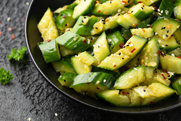 Wall Mural - Smashed cucumber spicy Asian style salad with soy sauce dressing, chilli flakes, garlic and sesame seeds