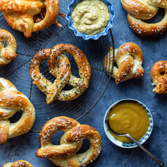 Baked pretzels on a cooling rack served with mustard dips.