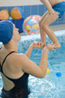 © ninelutsk - Toddler child learning to swim in indoor swimming pool with teacher. balancing in the water and general physical activity for kids, early development. Boy kid trained to kick legs