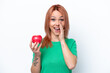 © luismolinero - Young Russian girl with an apple isolated on white background shouting with mouth wide open