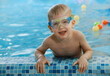 © ninelutsk - Happy cute toddler child near the pool side smiling in goggles after swimming lesson indoor. Physical development and healthy water activities for kids