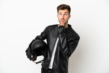 Sticker - Young caucasian man with a motorcycle helmet isolated on white background looking up while smiling