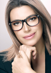 Poster - Attractive woman in spectacles and suit. Vertical beauty portrait on grey with copy space. women eyewear and clear vision concept