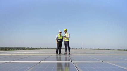 Wall Mural - professional engineer using drone and digital tablet maintaining solar cell panels together on build