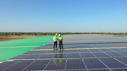 Wall Mural - professional engineer using drone and digital tablet maintaining solar cell panels together on build
