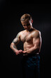 © Ilya - Man on black background keeps dumbbells pumped up in fitness bodybuilding biceps arm man lifting lifestyle. Young handsome power, guy fit