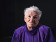 © Sergey - Portrait of serious senior woman against black background