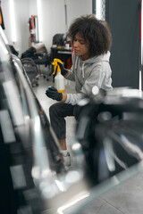 Canvas Print - Service station worker spraying clay lubricant over auto exterior