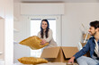 © Westend61 - Young couple unpacking cardboard boxes in bedroom and moving into new home