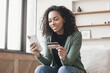 © kite_rin - Woman holding credit card and using smartphone at home, beautiful african american girl shopping online, e-commerce, internet banking, spending money, working from home concept