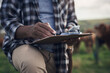 © Nicholas Felix/peopleimages.com - Dont work against nature, work with it. Shot of an unrecognisable man writing notes while working on a cow farm.