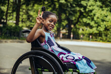 Disabled Girl In Wheelchair Making Peace Sign