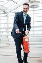 Happy Businessman With Fire Extinguisher Having Fun In Greenhouse