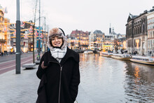 Smiling Woman In Winter Hat By Canal In City