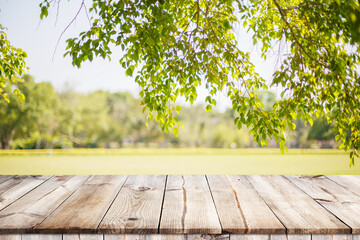 Empty wooden table with garden bokeh for a catering or food background with a country outdoor theme,Template mock up for display of product