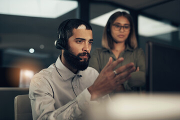 Aufkleber - I could use your help to figure this one out. Shot of a call centre agent working in an office alongside a colleague at night.
