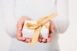 © sorapop - Valentine Day. Woman beauty hands holding small gift package box present wrapped paper with ribbon, Christmas, New year, Birthday holiday background concept