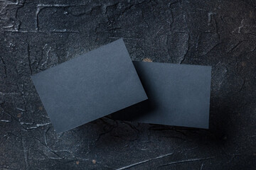 Wall Mural - Black business card mockup, front and back, on a dark background, a template for design presentation, thick cardboard visiting cards floating on black