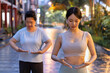 © 9nong - Two generation asian women doing traditional Chinese Tai Chi, Taiji, Taijiquan meditation in the evening, urban public park environment